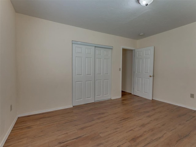 unfurnished bedroom with a closet and light hardwood / wood-style flooring