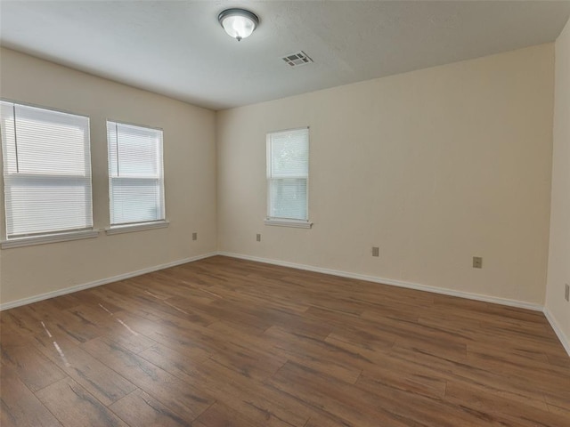 empty room with dark hardwood / wood-style flooring