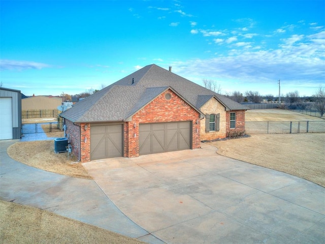 view of front of home featuring a garage and central AC