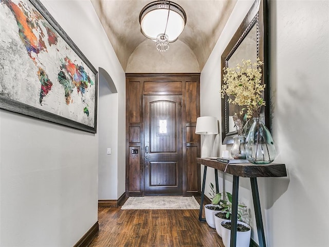 foyer entrance with brick ceiling, vaulted ceiling, and dark hardwood / wood-style floors