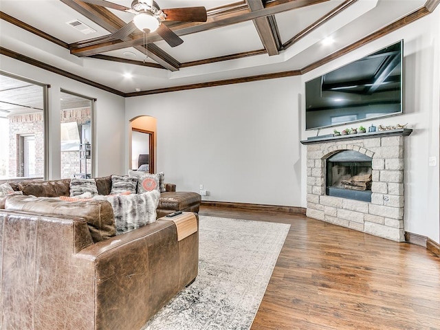 living room with coffered ceiling, hardwood / wood-style flooring, a fireplace, ceiling fan, and beamed ceiling