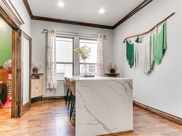 dining space featuring ornamental molding and wood-type flooring