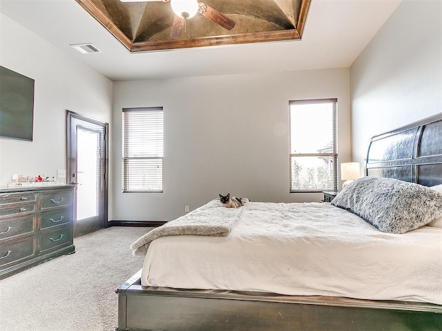 carpeted bedroom featuring multiple windows and ceiling fan