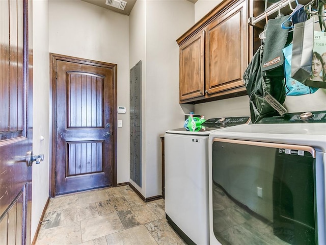 washroom featuring cabinets and washer and clothes dryer