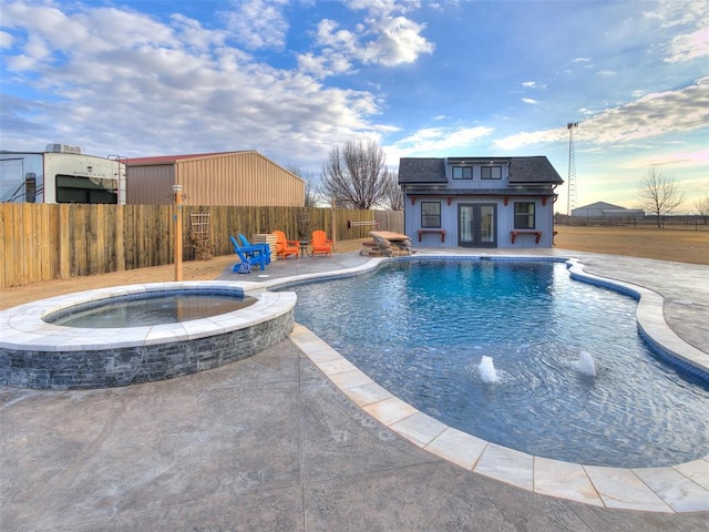 view of swimming pool with pool water feature, an in ground hot tub, an outdoor structure, and a patio area