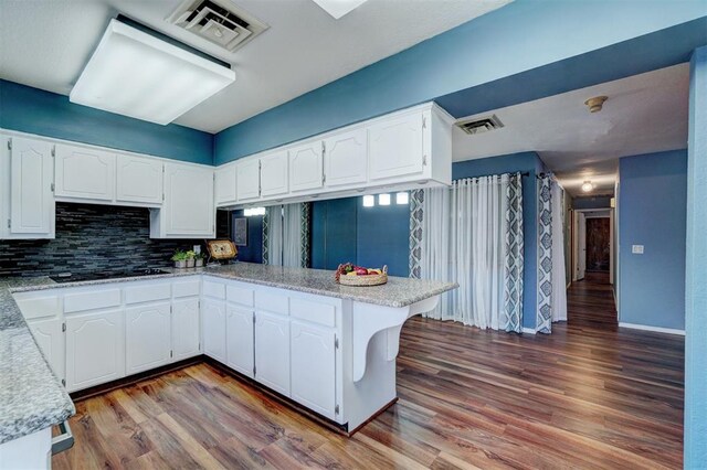 kitchen featuring white cabinetry, visible vents, and tasteful backsplash