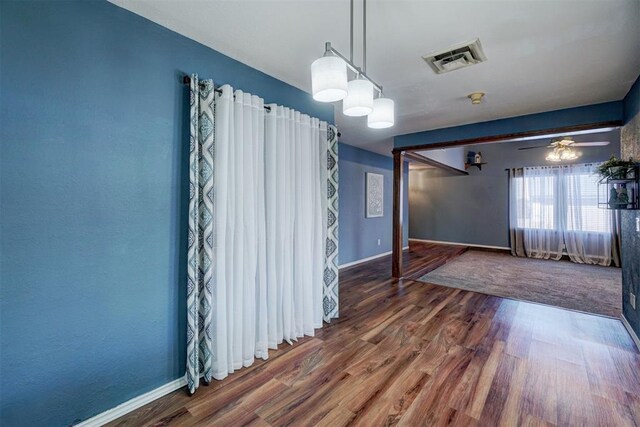 spare room featuring visible vents, baseboards, and wood finished floors