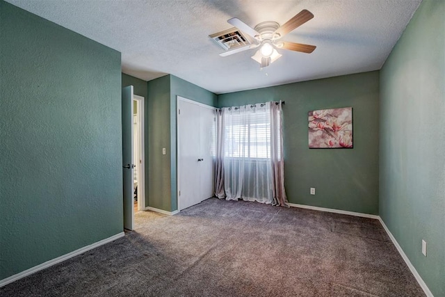unfurnished bedroom featuring visible vents, a textured ceiling, and carpet floors