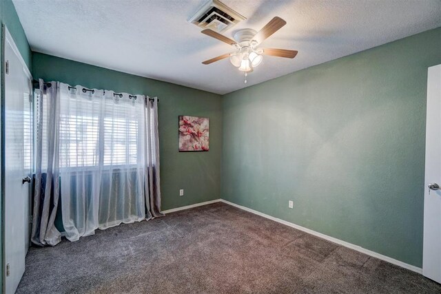 carpeted spare room with a ceiling fan, baseboards, visible vents, and a textured ceiling