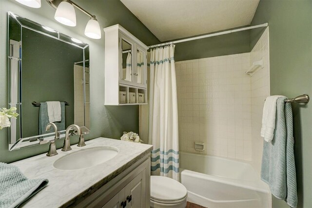 full bathroom featuring vanity, shower / bath combination with curtain, and toilet