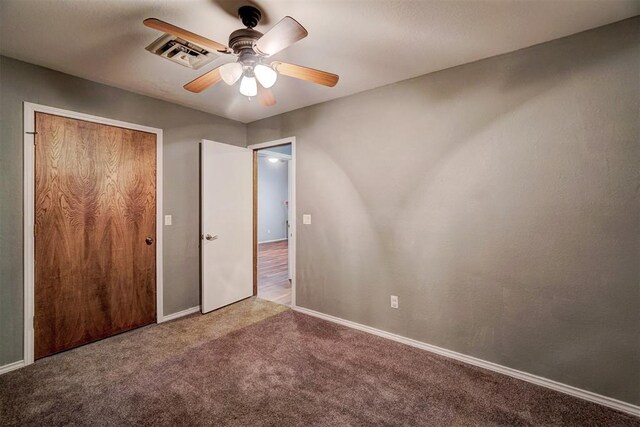 unfurnished bedroom with carpet flooring, a ceiling fan, baseboards, visible vents, and a closet