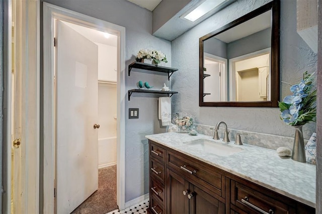bathroom featuring a textured wall and vanity