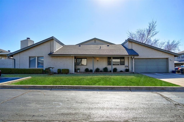 single story home with an attached garage, driveway, a chimney, and a front yard