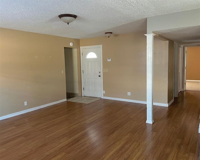 foyer entrance with a textured ceiling and dark hardwood / wood-style floors