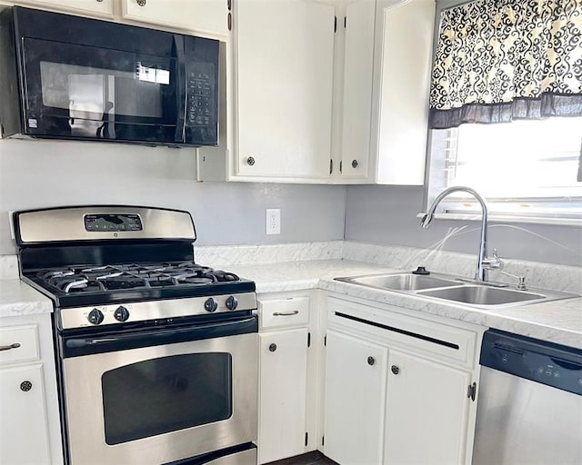 kitchen with sink, appliances with stainless steel finishes, and white cabinetry