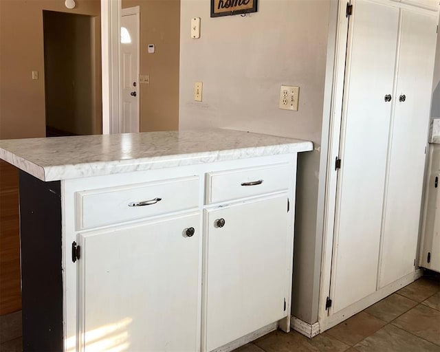 kitchen with white cabinets, tile patterned flooring, and kitchen peninsula