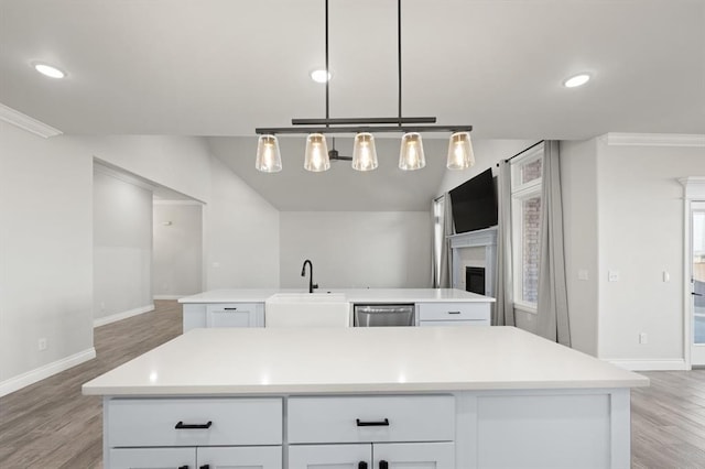 kitchen featuring a sink, a center island with sink, light wood-style floors, white cabinets, and stainless steel dishwasher