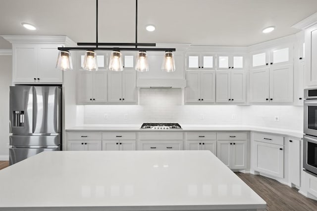 kitchen with dark wood finished floors, white cabinetry, stainless steel appliances, and light countertops