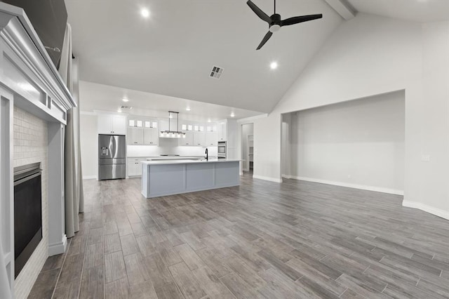 kitchen with wood finished floors, visible vents, a sink, stainless steel appliances, and light countertops