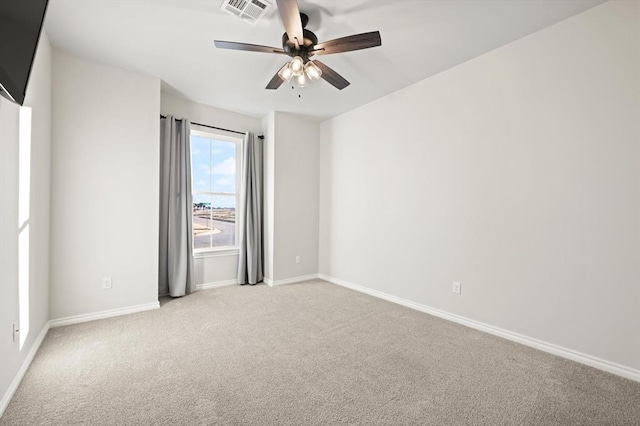 unfurnished room with baseboards, visible vents, carpet floors, and ceiling fan