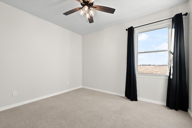 unfurnished room featuring light carpet, a ceiling fan, and baseboards