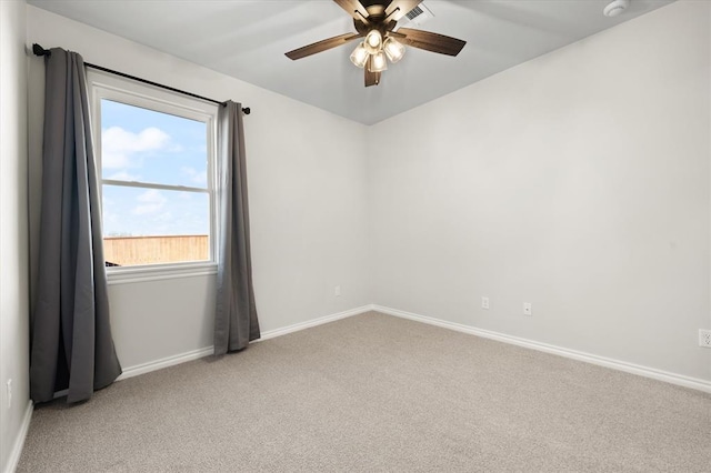 unfurnished room with visible vents, light colored carpet, baseboards, and ceiling fan