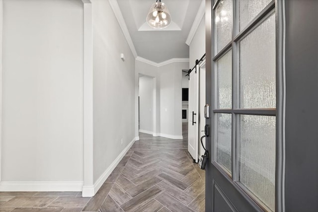 entryway featuring a barn door, baseboards, and ornamental molding