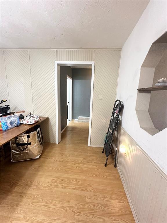 hall featuring light hardwood / wood-style flooring and a textured ceiling