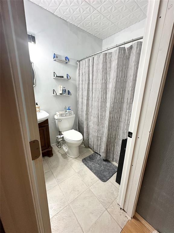 bathroom with vanity, tile patterned floors, toilet, and a shower with shower curtain