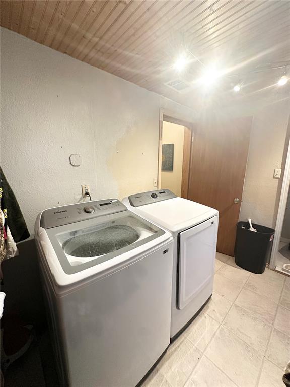 laundry room featuring wood ceiling and separate washer and dryer