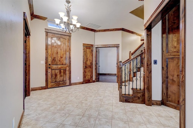 entrance foyer with an inviting chandelier, ornamental molding, and light tile patterned floors