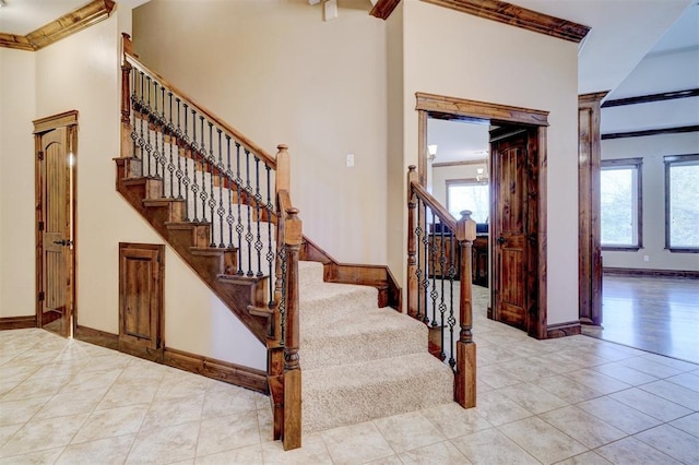 stairway with tile patterned flooring, a healthy amount of sunlight, and crown molding