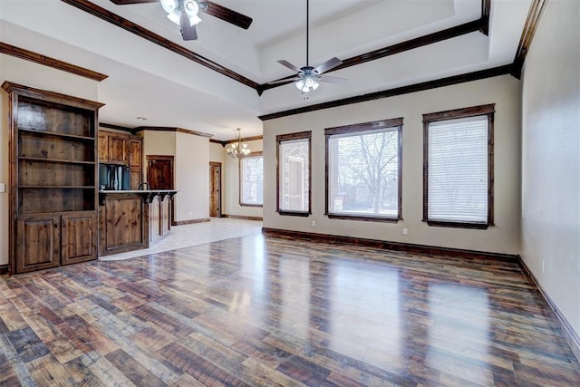 unfurnished living room featuring ceiling fan with notable chandelier, dark wood-type flooring, and ornamental molding