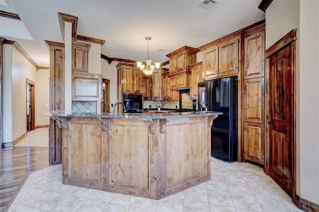 kitchen with black appliances, crown molding, dark stone counters, pendant lighting, and decorative backsplash