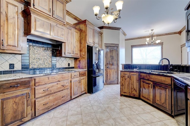 kitchen with decorative light fixtures, light stone counters, black appliances, and a chandelier