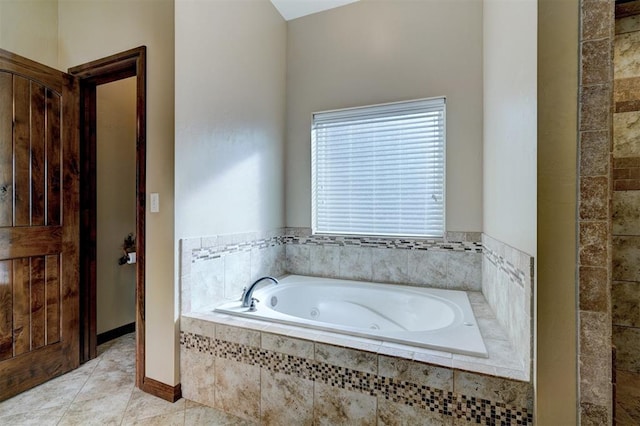 bathroom with tiled tub and tile patterned flooring