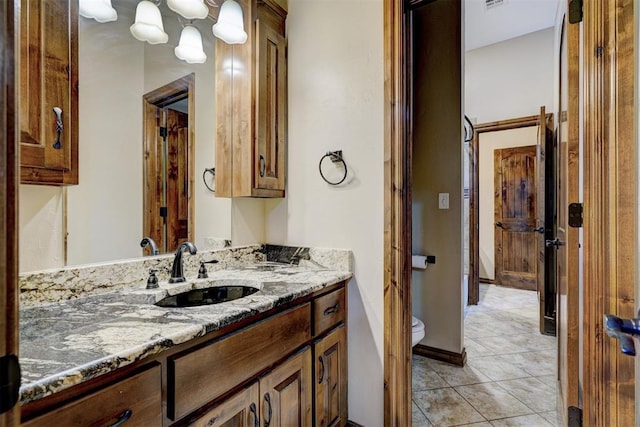 bathroom with tile patterned flooring, vanity, and toilet