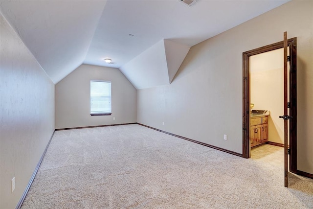 additional living space with vaulted ceiling and light colored carpet