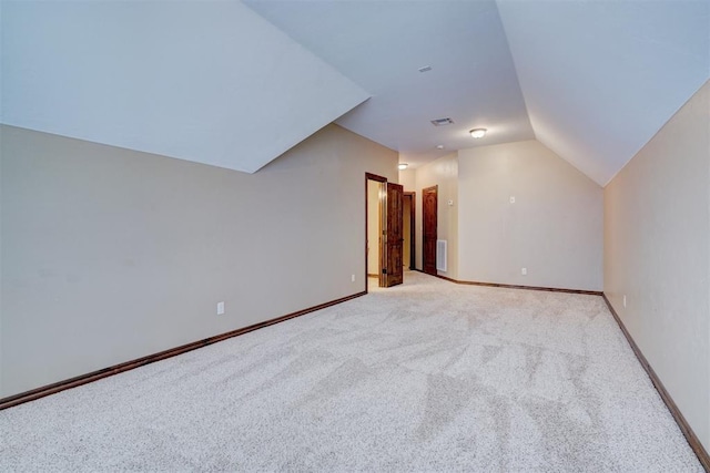 additional living space featuring light carpet and lofted ceiling