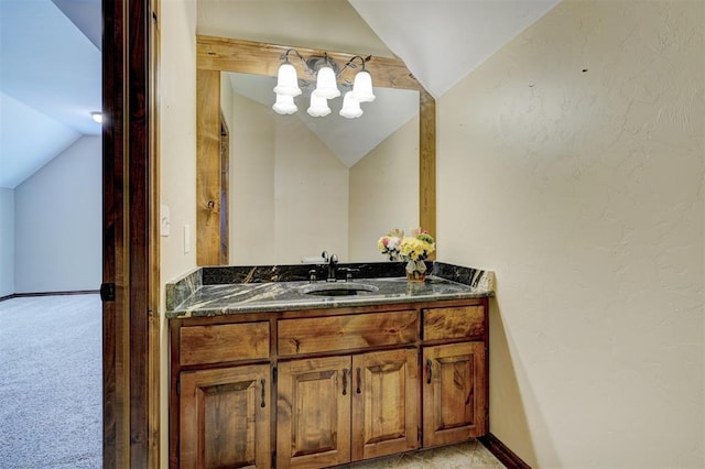 bathroom with vaulted ceiling and vanity