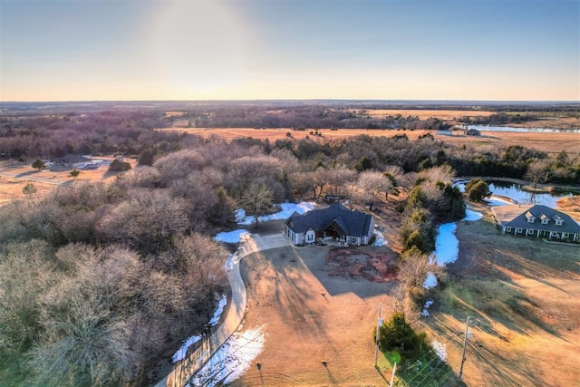 aerial view at dusk with a water view and a rural view