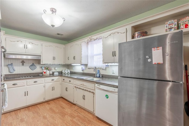 kitchen with white cabinetry, dishwasher, and stainless steel fridge