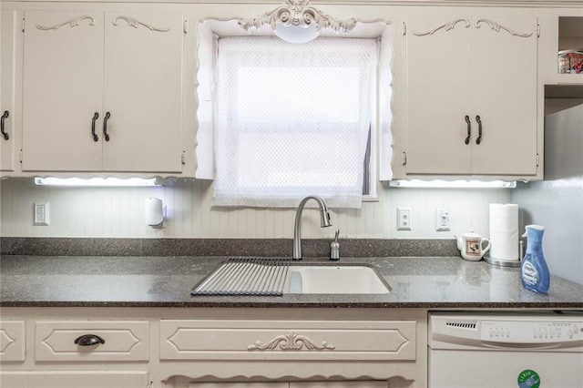 kitchen featuring sink, white dishwasher, and white cabinetry