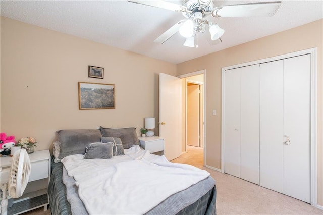 carpeted bedroom with ceiling fan and a closet