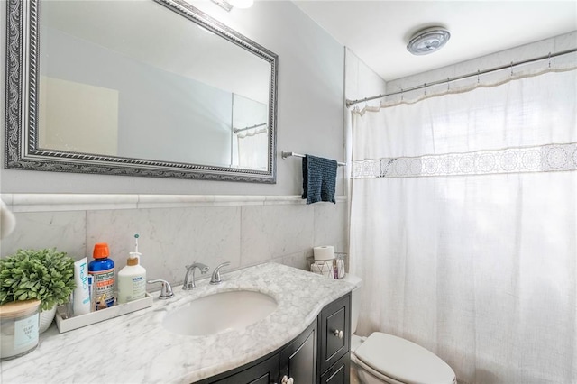 bathroom featuring toilet, curtained shower, tile walls, and vanity