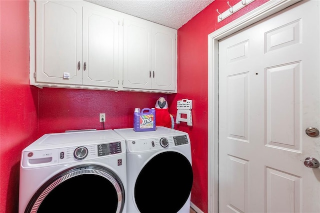 washroom featuring a textured ceiling, cabinets, and washer and clothes dryer