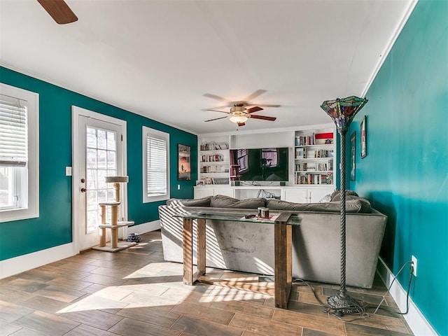 living room with built in features and crown molding