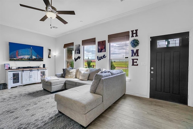 living room with hardwood / wood-style flooring, beverage cooler, ornamental molding, and ceiling fan