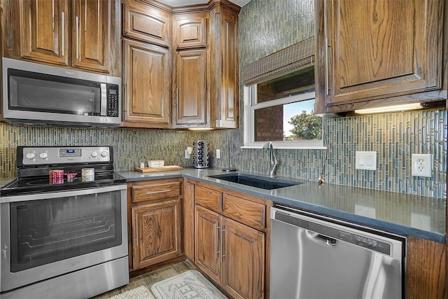 kitchen featuring decorative backsplash, appliances with stainless steel finishes, and sink