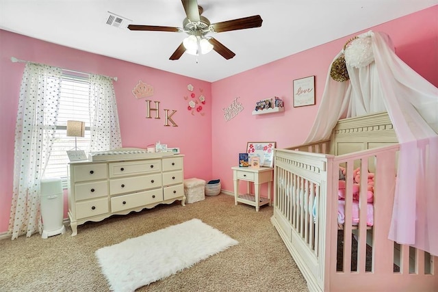 bedroom featuring ceiling fan, a nursery area, and carpet flooring